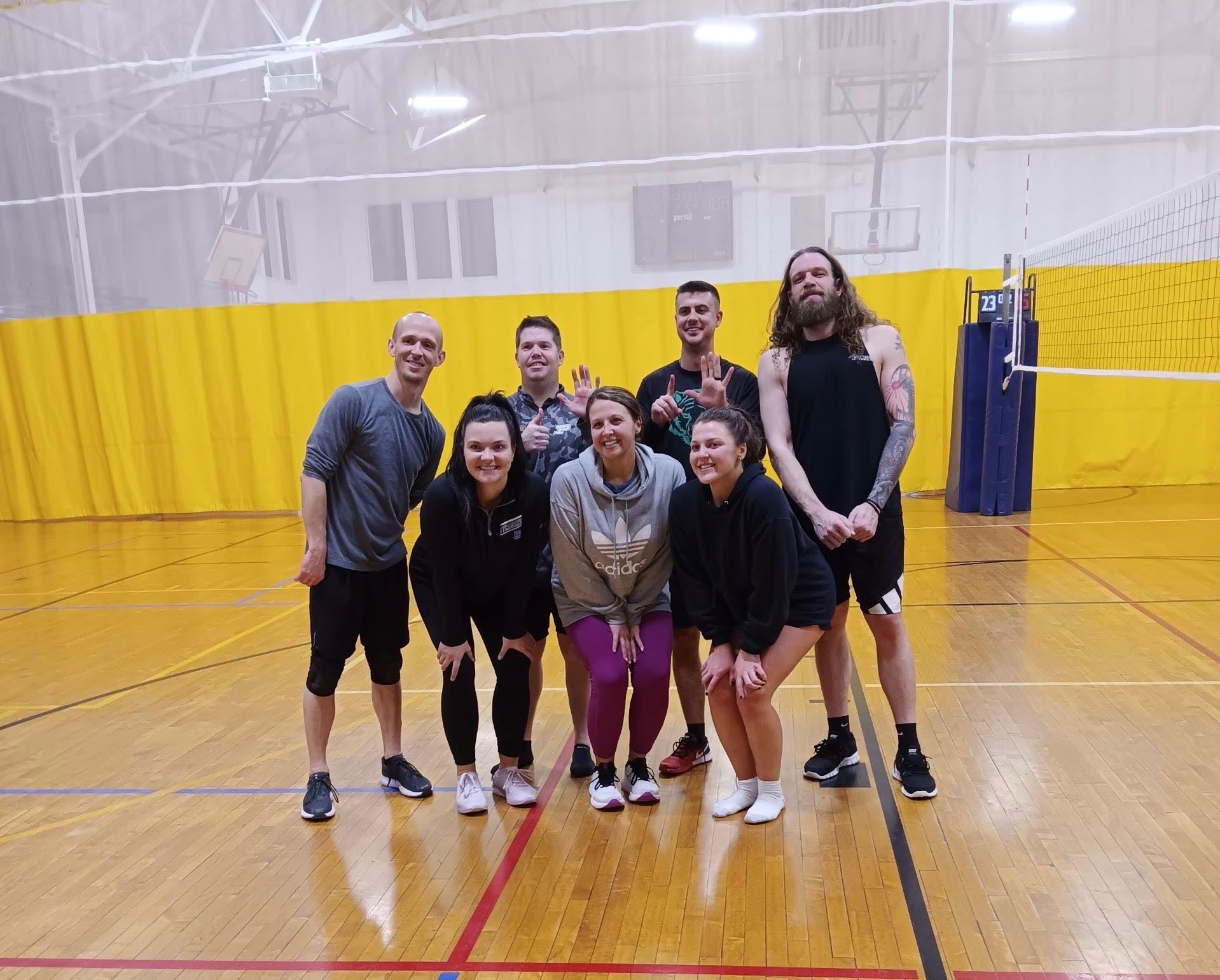 group photo of volleyball coed team in parks gymnasium